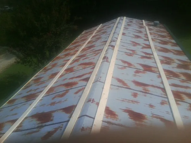 Rusted metal roof panels with new wood purlins before replacement — Storm Damage Roof Repair in Junction City by Roofing Brothers