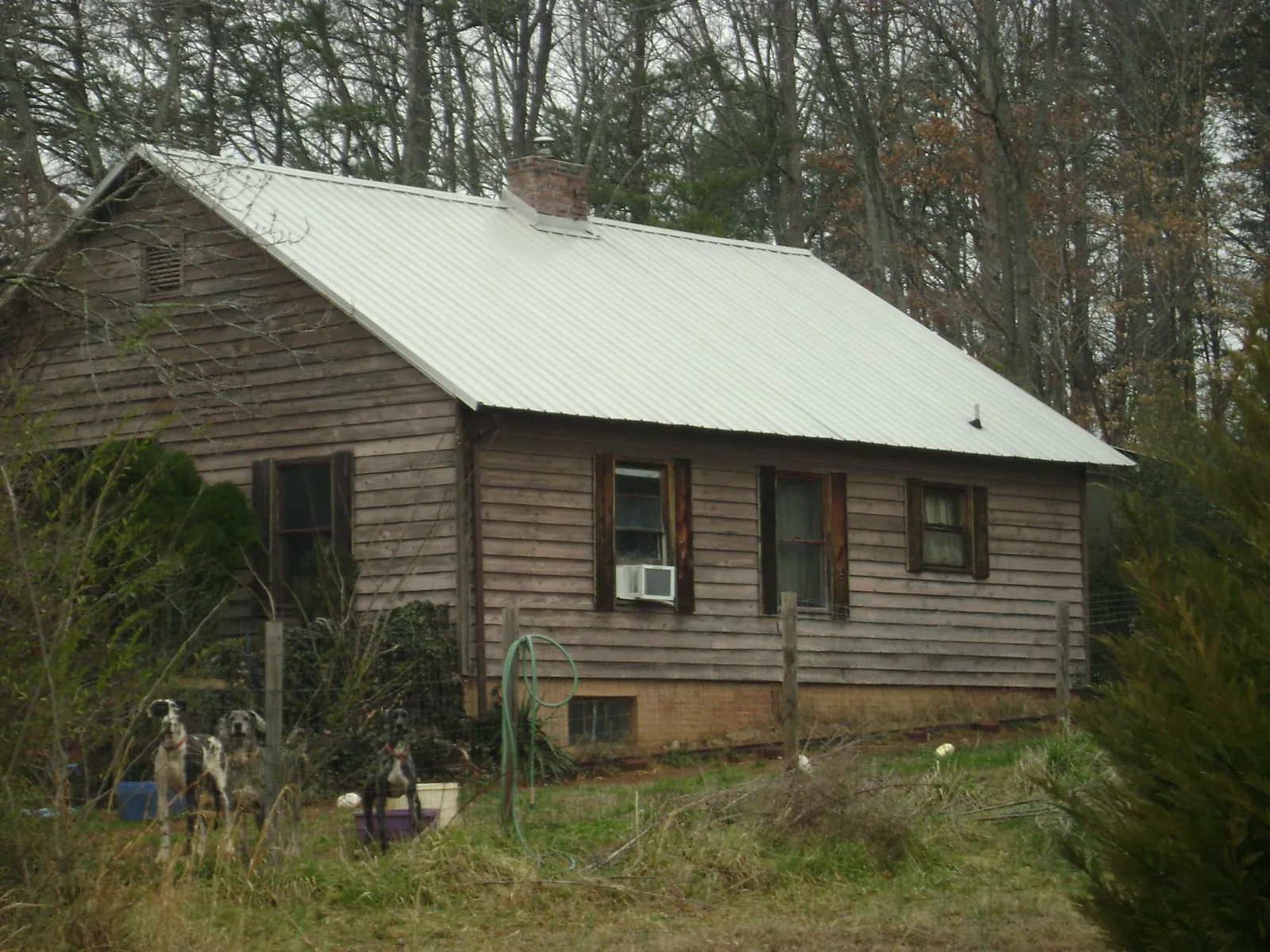 White metal roof on an old wood sided farmhouse, from a Asphalt Shingle Roof Repair job in Junction City